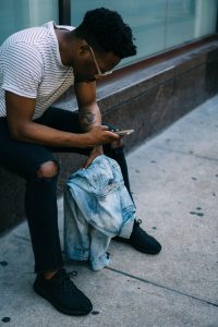 man hunched over looking at his phone